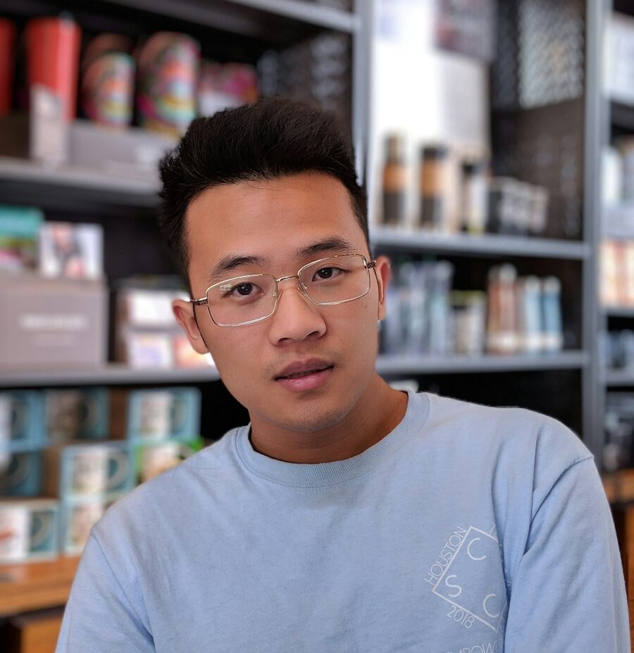 man wearing eyeglasses and blue shirt inside coffee shop